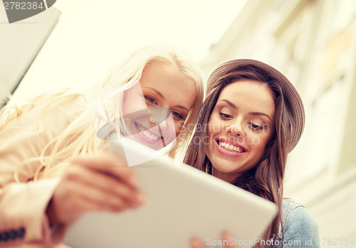 Image of two beautiful girls looking into tablet pc
