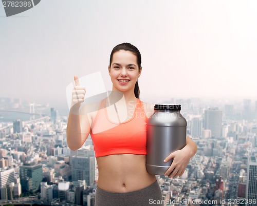 Image of teenage girl with jar of protein showing thumbs up