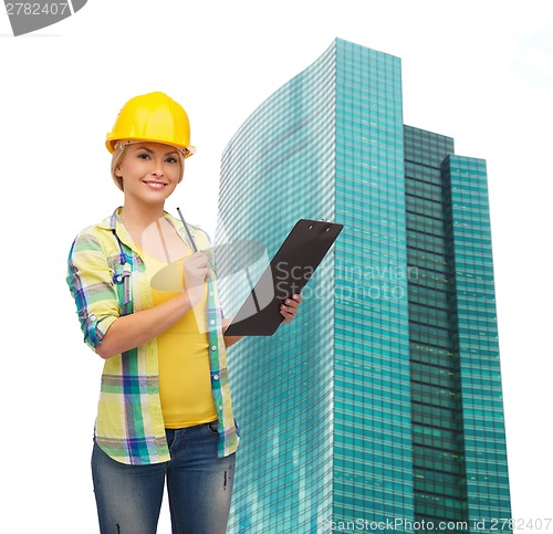 Image of smiling woman in helmet with clipboard