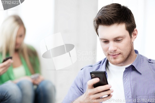 Image of student looking at phone and tiping