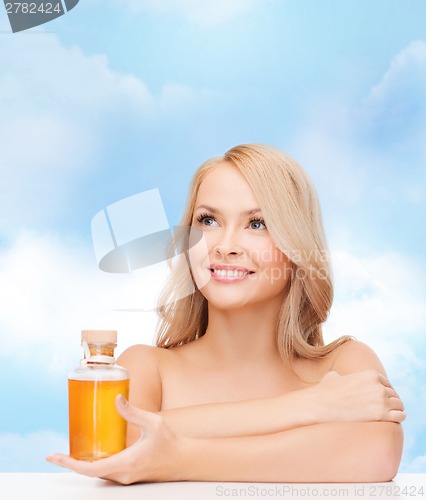 Image of happy woman with oil bottle