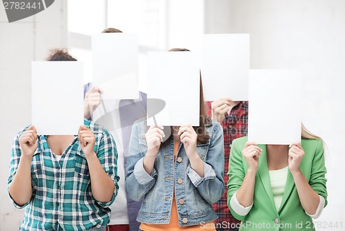 Image of students covering faces with blank papers