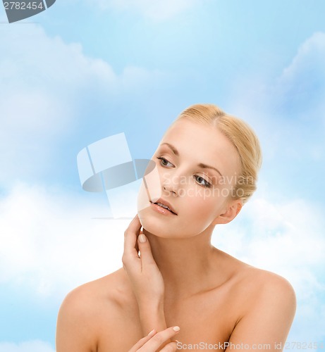 Image of beautiful woman touching her face skin