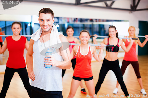 Image of smiling trainer in front of group of people