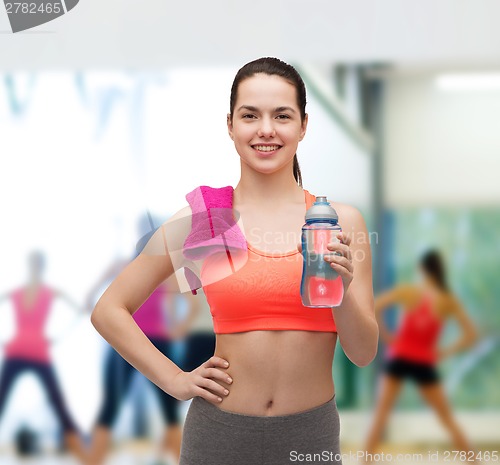 Image of sporty woman with towel and water bottle