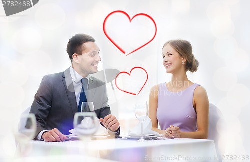 Image of smiling couple looking at each other at restaurant