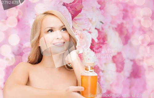 Image of happy woman with oil bottle