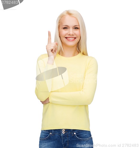 Image of smiling woman pointing her finger up