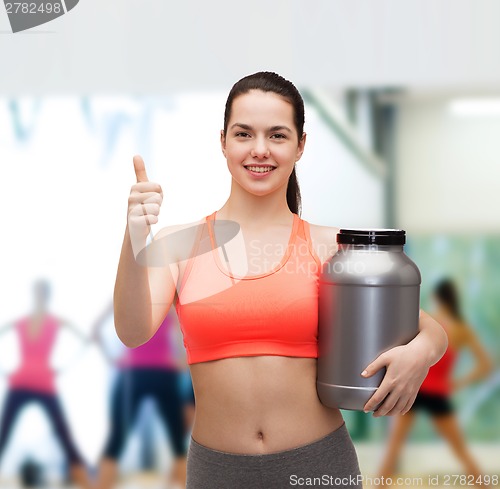 Image of teenage girl with jar of protein showing thumbs up