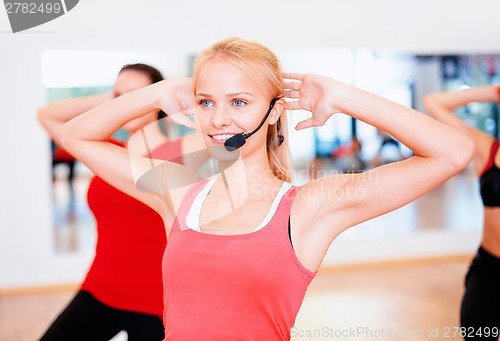 Image of group of smiling people exercising in the gym