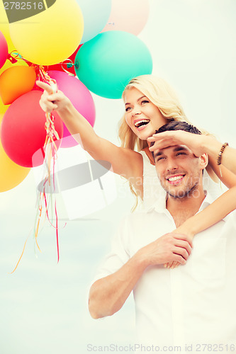 Image of couple with colorful balloons at seaside