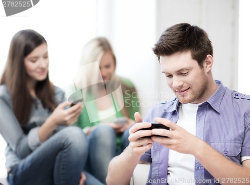 Image of students looking into devices at school