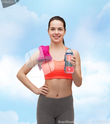 Image of sporty woman with towel and water bottle