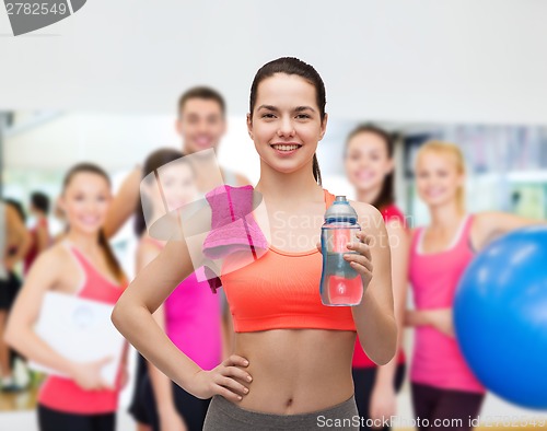 Image of sporty woman with towel and water bottle