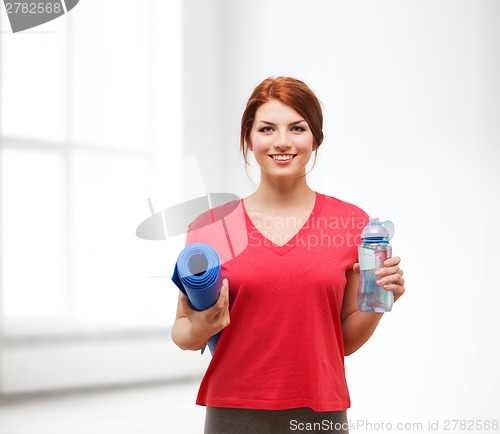 Image of smiling girl with bottle of water after exercising