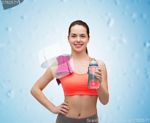 Image of sporty woman with towel and water bottle