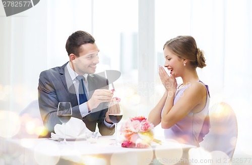 Image of man proposing to his girlfriend at restaurant