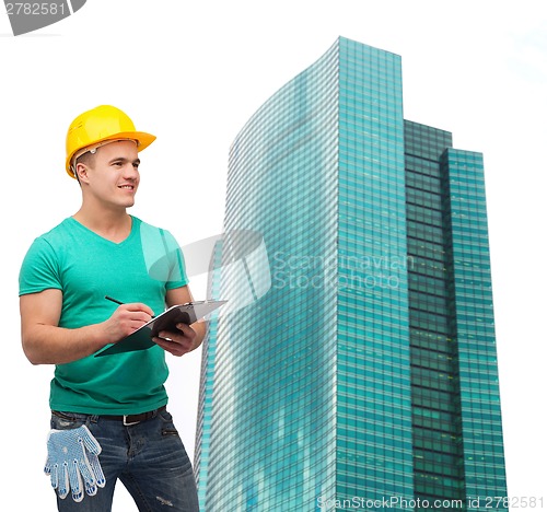 Image of smiling man in helmet with clipboard