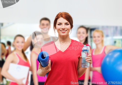 Image of smiling girl with bottle of water after exercising