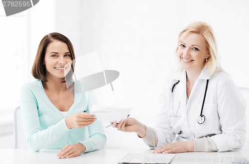 Image of doctor giving prescription to patient in hospital