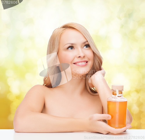 Image of happy woman with oil bottle