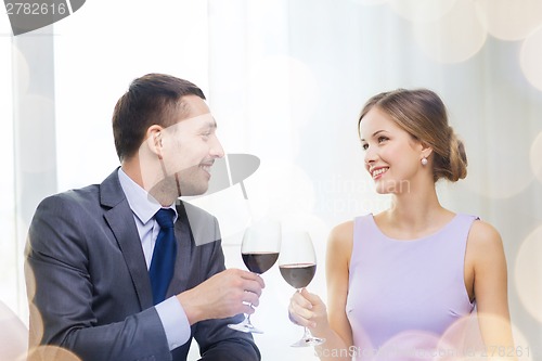 Image of young couple with glasses of wine at restaurant