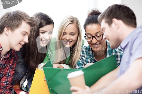 Image of students looking at notebook at school