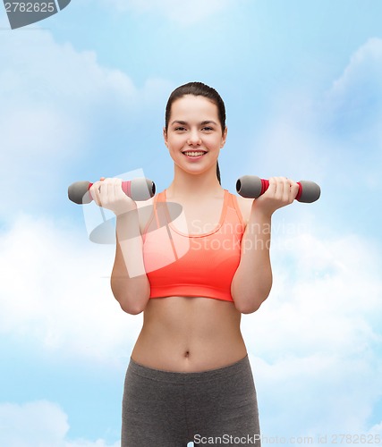Image of young sporty woman with light dumbbells