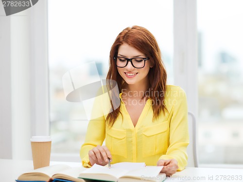 Image of smiling student girl reading books in library