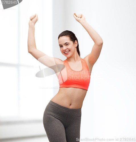 Image of smiling teenage girl in sportswear dancing