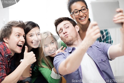 Image of students making picture with tablet pc at school