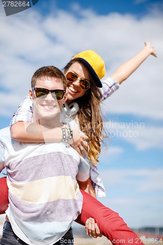 Image of smiling teenagers in sunglasses having fun outside