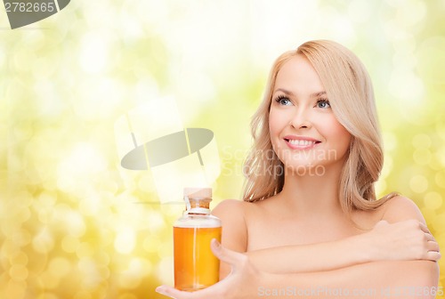 Image of happy woman with oil bottle