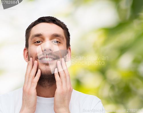 Image of beautiful smiling man touching his face