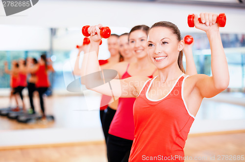 Image of group of smiling people working out with dumbbells