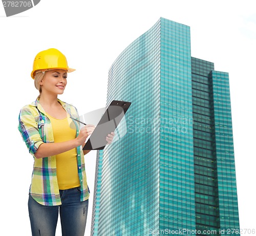 Image of smiling woman in helmet with clipboard