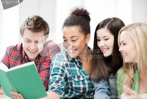 Image of students reading book at school