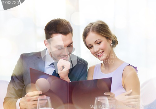 Image of smiling couple with menu at restaurant
