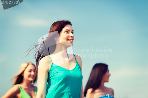 Image of girl with friends walking on the beach