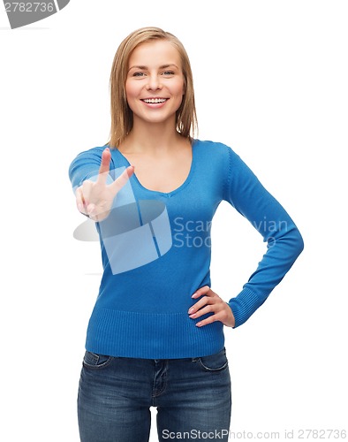 Image of smiling teenage girl showing v-sign with hand