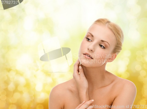 Image of beautiful woman touching her face skin