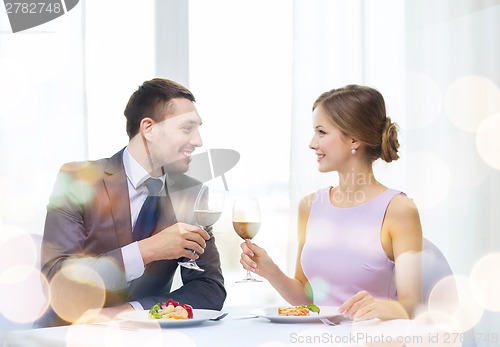 Image of couple with main course and red wine at restaurant