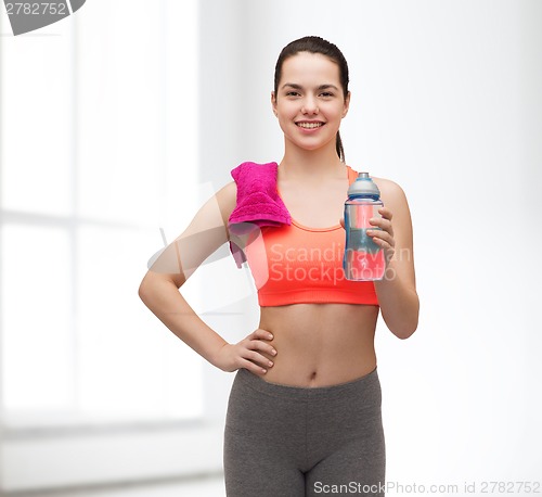 Image of sporty woman with towel and water bottle