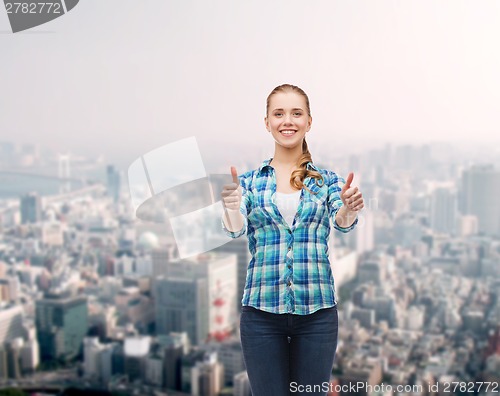 Image of young woman in casual clothes showing thumbs up