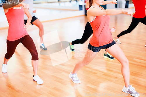 Image of group of smiling people exercising in the gym