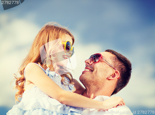 Image of happy father and child in sunglasses over blue sky