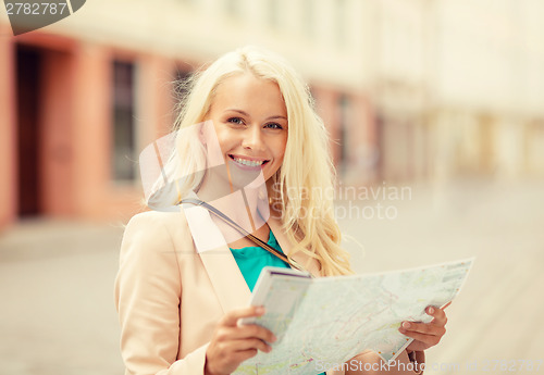 Image of smiling girl with tourist map in the city