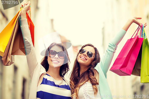 Image of smiling girls in sunglasses with shopping bags