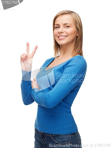 Image of smiling teenage girl showing v-sign with hand