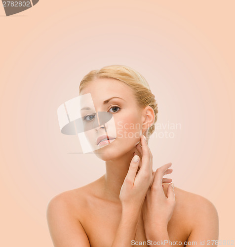 Image of beautiful woman touching her face skin